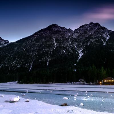 Sunset on the icy lake of Dobbiaco